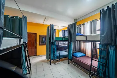 a room with three bunk beds in a house at Sandy Toes Hostel in Sámara