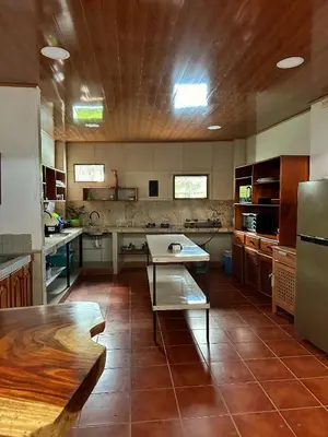 a large kitchen with a table in the middle of it at Sandy Toes Hostel in Sámara
