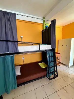a room with two bunk beds and a bathroom at Sandy Toes Hostel in Sámara