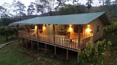 a large wooden cabin with a blue tin roof at Finca Amistad Cacao Lodge in Bijagua