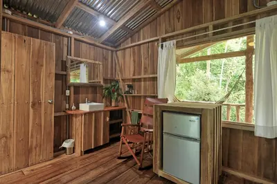 a room with a tv and a desk and a window at Finca Amistad Cacao Lodge in Bijagua