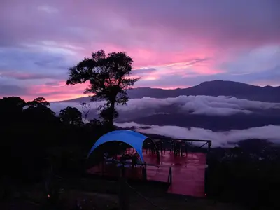 a tent on a hill with a view of the clouds at Reventazon River Mountain Ranch in Turrialba