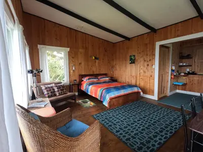 a bedroom with a bed and a table and chairs at Reventazon River Mountain Ranch in Turrialba