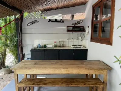 a kitchen with a wooden table and a counter at Beach Cabinas in Santa Teresa Beach