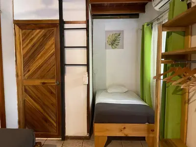 a small room with a bed and a door at Beach Cabinas in Santa Teresa Beach