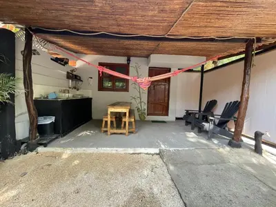 a patio with chairs and a table with a red ribbon at Beach Cabinas in Santa Teresa Beach