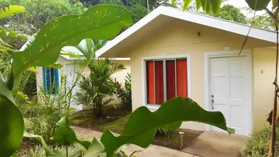 a small house with a red and white door at Tropical Paradise Bungalows in Pital