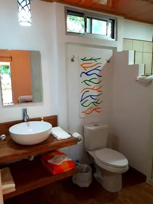 a bathroom with a sink and a toilet at Tropical Paradise Bungalows in Pital