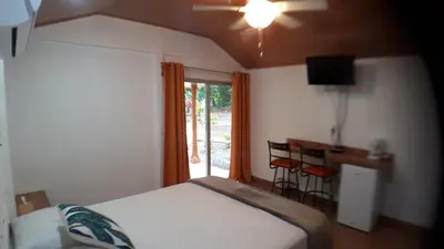 a bedroom with a bed and a desk and a window at Tropical Paradise Bungalows in Pital
