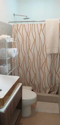a bathroom with a toilet and a shower curtain at Pura Vida Condo in Tamarindo