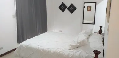 a white bed in a room with a window at Pura Vida Condo in Tamarindo