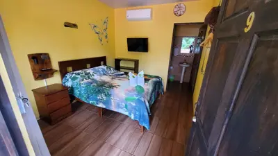 a bedroom with a bed in a room with yellow walls at Tropical Beach in Uvita