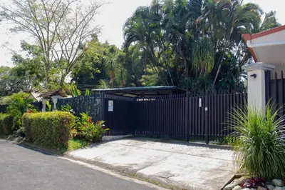 a black fence in front of a house at Terida Airport B&B in Alajuela City