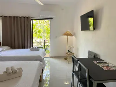 a room with two beds and a table and a desk at La Jungla in Carrillo