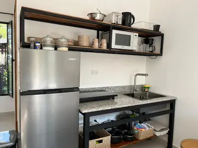a kitchen with a stainless steel refrigerator and a microwave at La Jungla in Carrillo