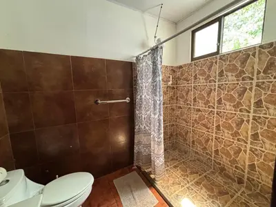 a bathroom with a toilet and a shower at La Jungla in Carrillo