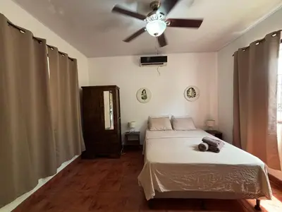 a bedroom with a bed and a ceiling fan at La Jungla in Carrillo