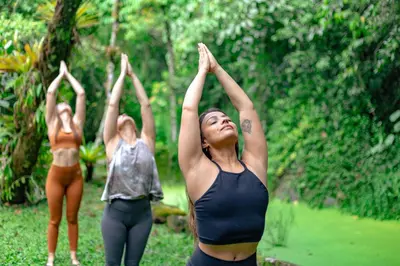 three women are doing yoga in a forest at Rio Chirripo in Rivas