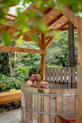 two men in a hot tub in a wooden gazebo at Rio Chirripo in Rivas