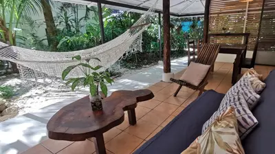 a porch with a hammock and a table and chairs at Colibri Apartments - Private kitchen & bathroom - 4 min walk to the Beach! in Santa Teresa Beach