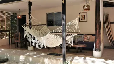 a hammock in the living room of a house at Colibri Apartments - Private kitchen & bathroom - 4 min walk to the Beach! in Santa Teresa Beach