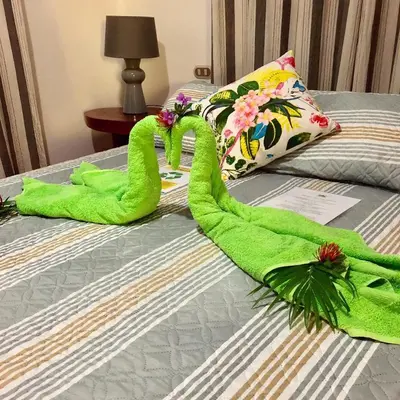 a bed with two green towel swans on it at Villas Verdes in Sámara