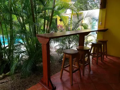 a table and stools in a room with plants at Villas Verdes in Sámara