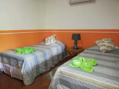 two beds in a room with green towels on them at Villas Verdes in Sámara