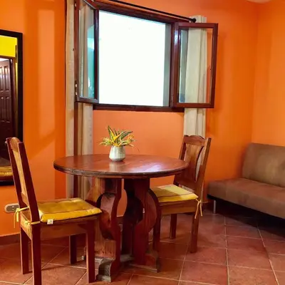 a table and chairs in a room with a window at Villas Verdes in Sámara