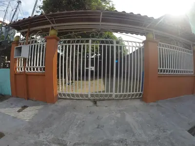 an open gate with a white fence at Casa Quepos in Quepos