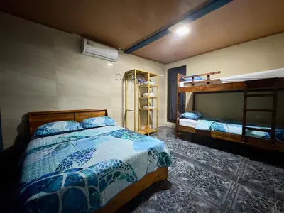 a bedroom with two beds and a bunk bed at Casa Quepos in Quepos