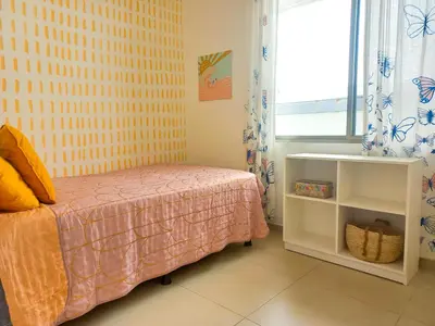 a small bedroom with a bed and a window at Calma Apartments Costa Rica in Mal País