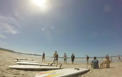 a group of people standing on a beach with surfboards at Burnt Toast Surfcamp in Nosara