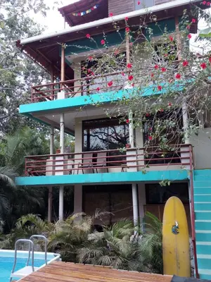 a blue building with a surfboard in front of it at Burnt Toast Surfcamp in Nosara
