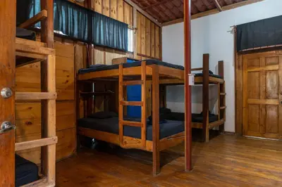 a room with three bunk beds in a cabin at Burnt Toast Surfcamp in Nosara