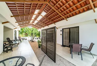 an open patio with chairs and tables and a ceiling at Las Perlitas Rentals Playa Samara in Sámara