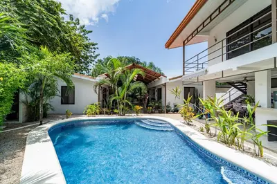 an image of a swimming pool in front of a house at Las Perlitas Rentals Playa Samara in Sámara