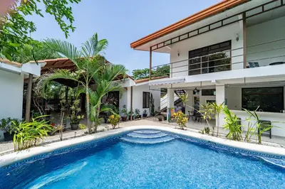 a swimming pool in front of a house at Las Perlitas Rentals Playa Samara in Sámara