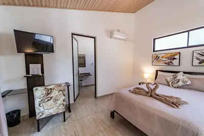 a bedroom with a bed and a mirror and a television at Las Perlitas Rentals Playa Samara in Sámara
