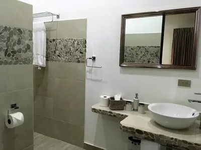 a bathroom with a sink and a glass shower at Las Perlitas Rentals Playa Samara in Sámara