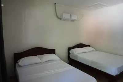 two beds in a small room with white sheets at Villa Vilar in Coco