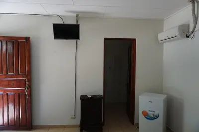 a room with a refrigerator and a television on a wall at Villa Vilar in Coco