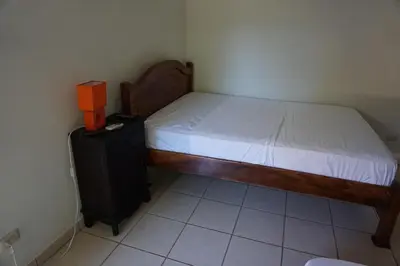 a small bedroom with a bed and a black cabinet at Villa Vilar in Coco