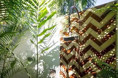 a building with a fence with plants in front of it at The Nomadic Hotel in Nosara