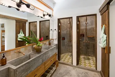 a bathroom with a double sink and a shower at The Nomadic Hotel in Nosara