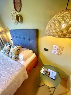 a small bedroom with a bed and a table at Hotel y Cabinas del Trópico in Guápiles