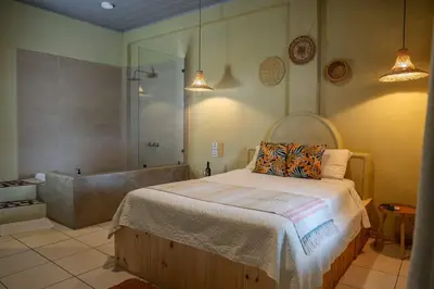 a bedroom with a bed and a bath tub at Hotel y Cabinas del Trópico in Guápiles