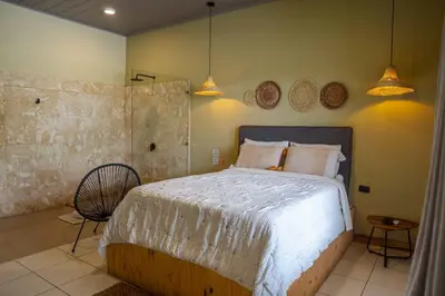 a bedroom with a large bed and two pendant lights at Hotel y Cabinas del Trópico in Guápiles