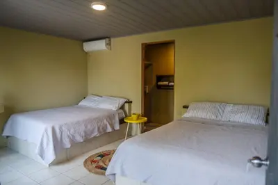 a bedroom with two beds and a door with a door at Hotel y Cabinas del Trópico in Guápiles