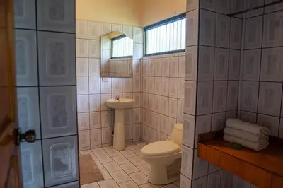 a bathroom with a toilet and a sink at Hotel y Cabinas del Trópico in Guápiles